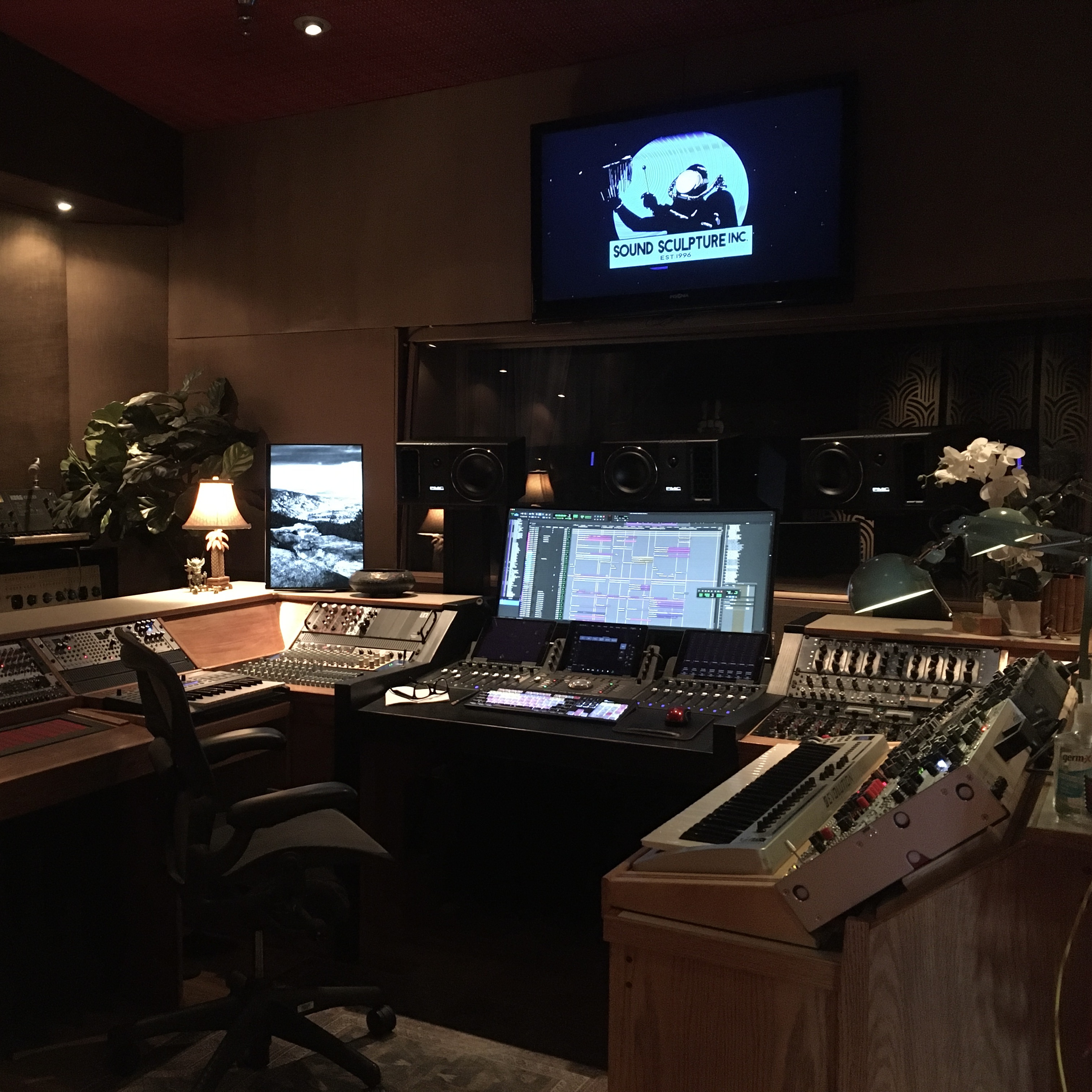 Sound design studio with mixing console and monitoring speakers.